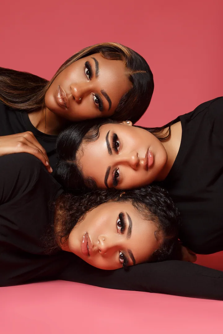 Three beauty portraits composed closely together against a vivid pink background