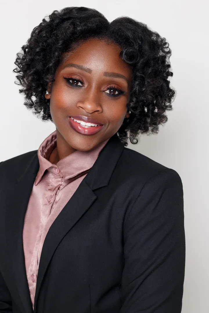 Professional in a dark blazer and pink shirt photographed on white
