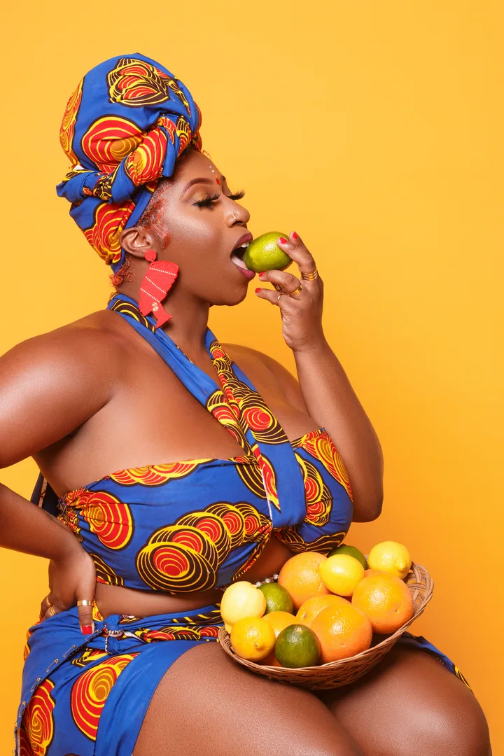 Colorful studio portrait with citrus fruit and a golden backdrop