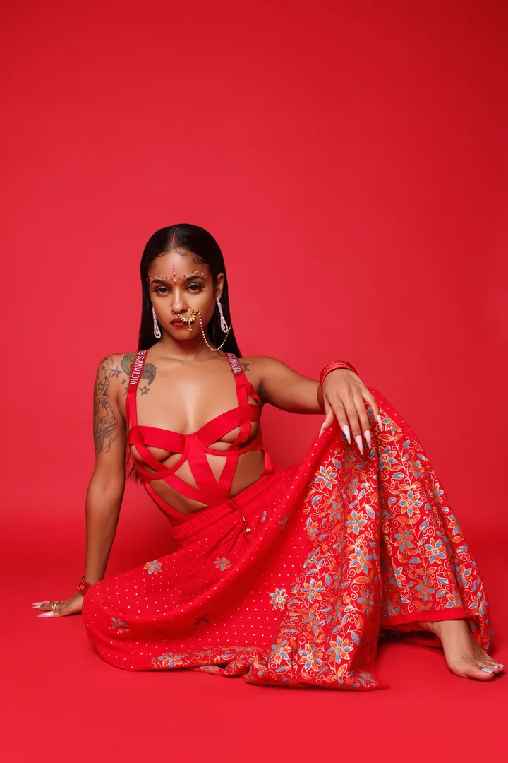Fashion portrait with flowing red fabric against a red backdrop